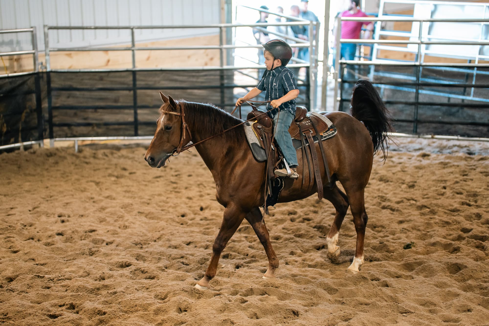Young rider on horseback inside the Double L Ranch arena